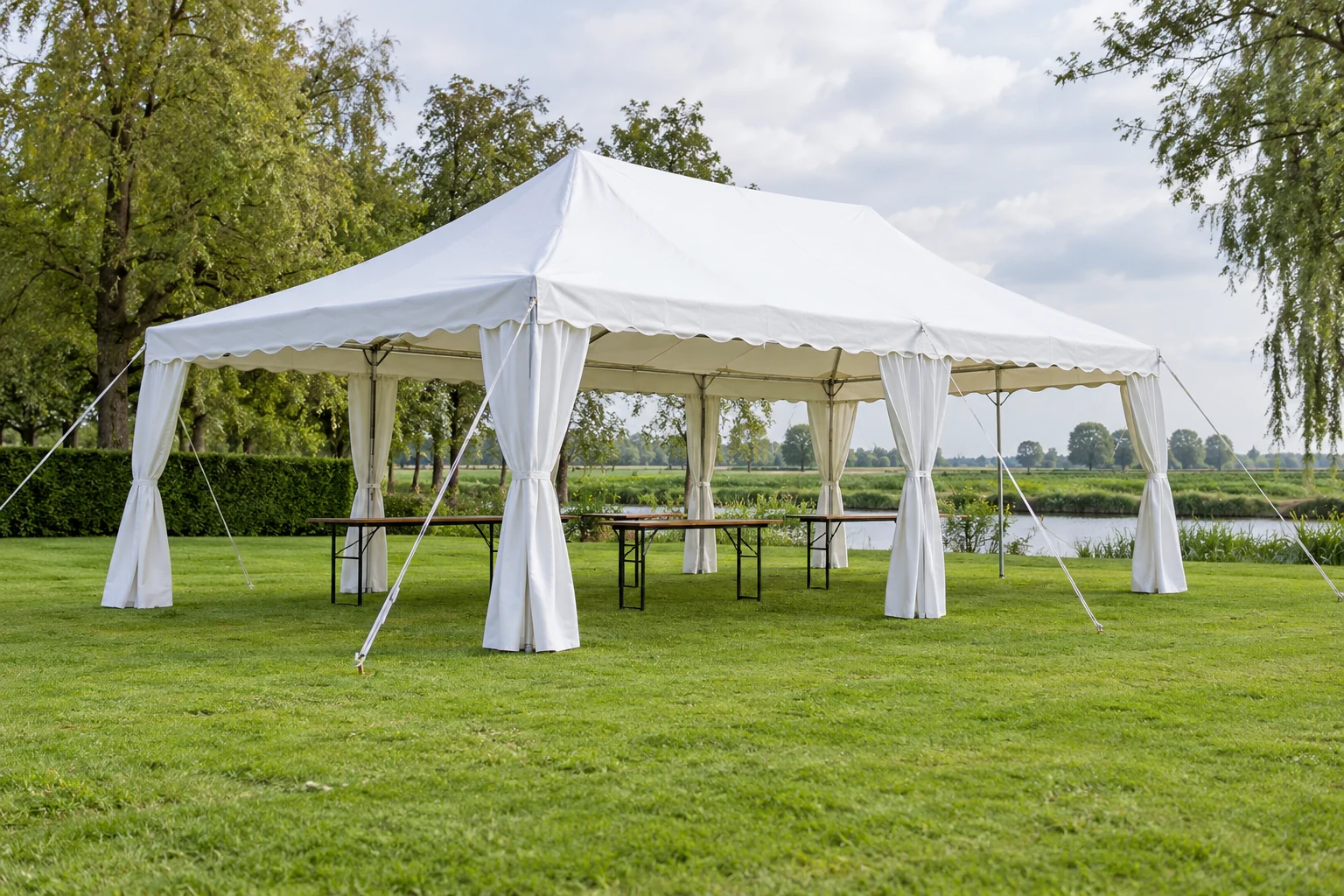 Witte feesttent met zijwanden op een grasveld