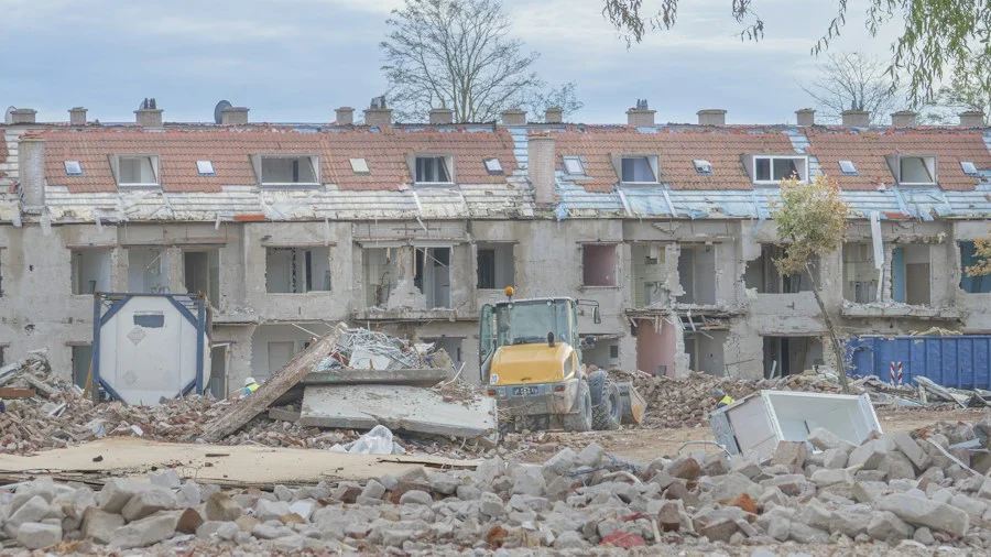 Sloopwerkzaamheden aan een gebouw met een sloopmachine